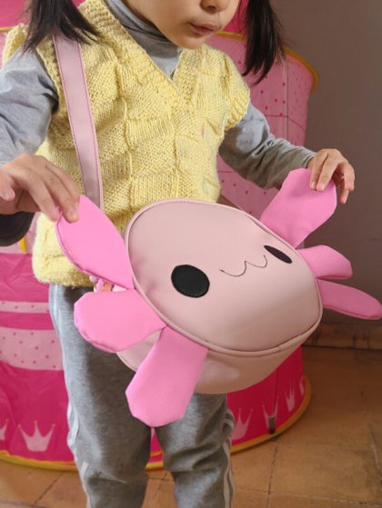 fotografía de una niña con usando nuestra bolsa de ajolote color rosa